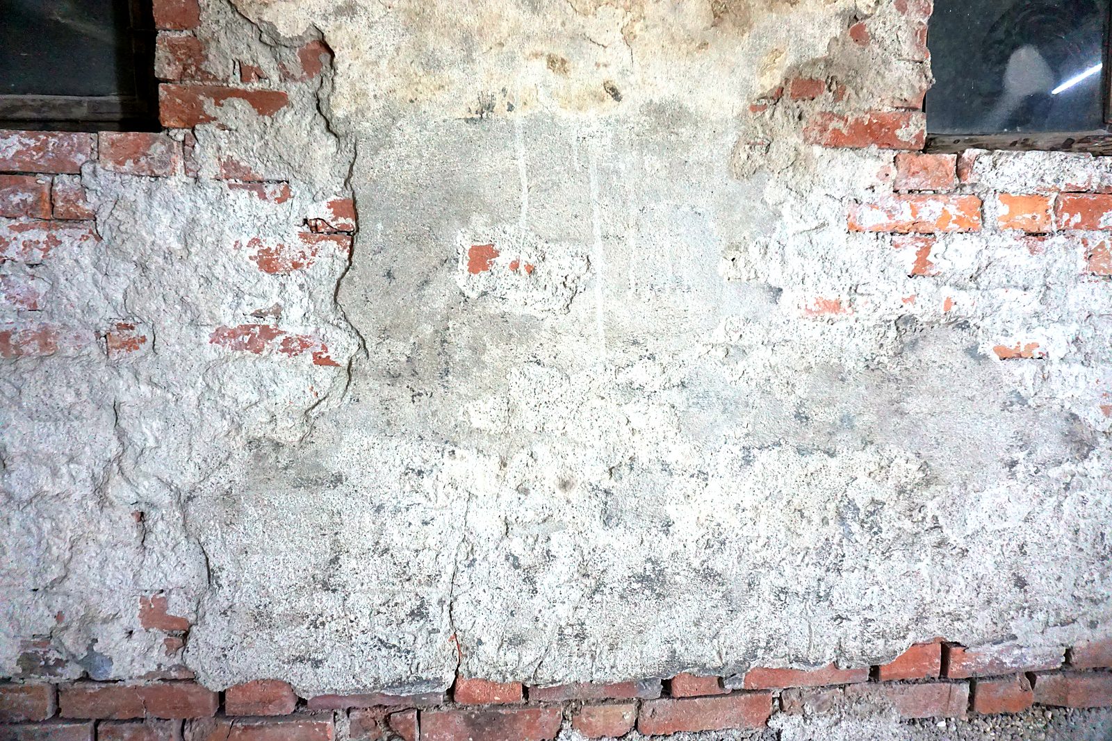 Facade with old render and paint residues before blasting