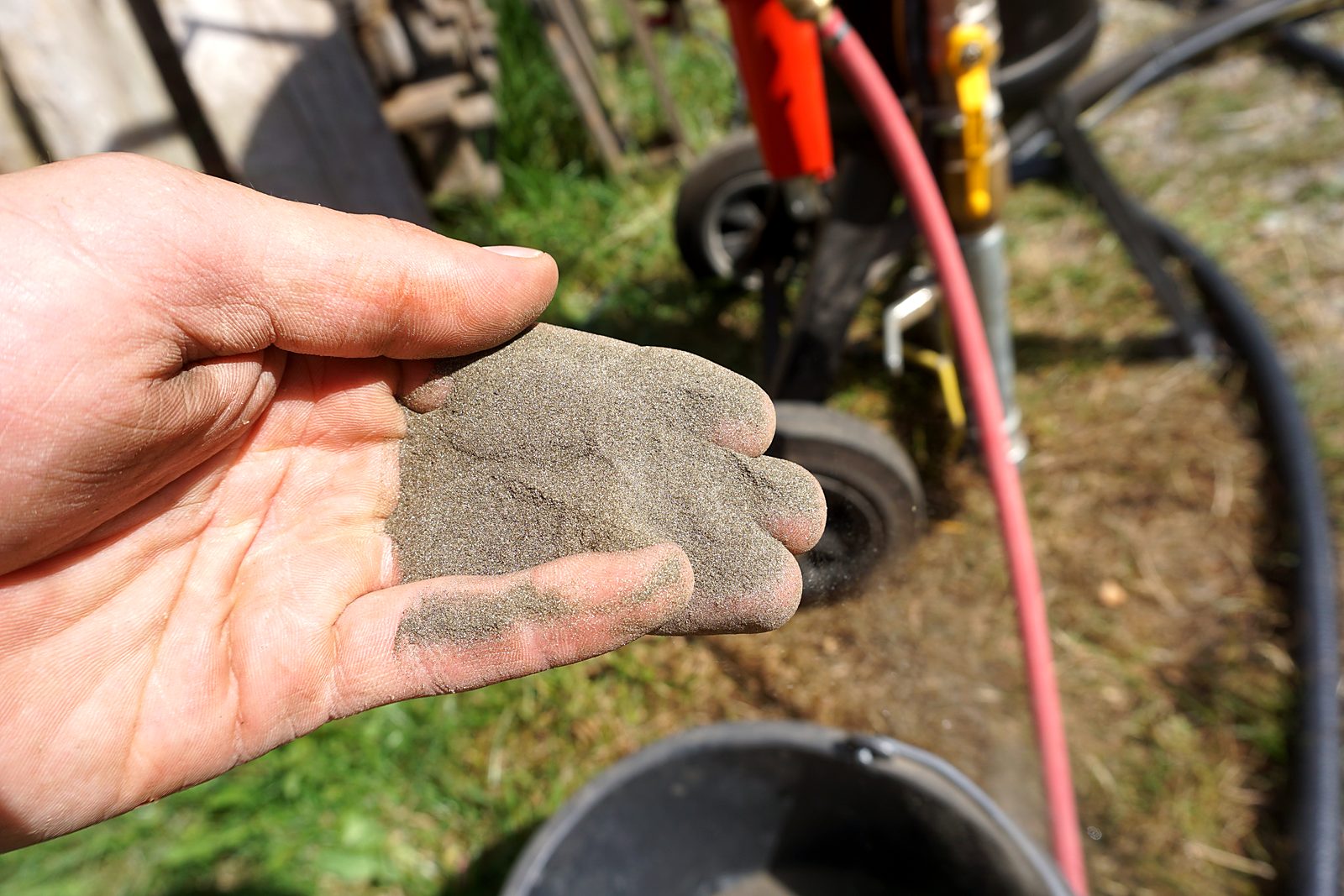 Fine mineral blast media held in a hand