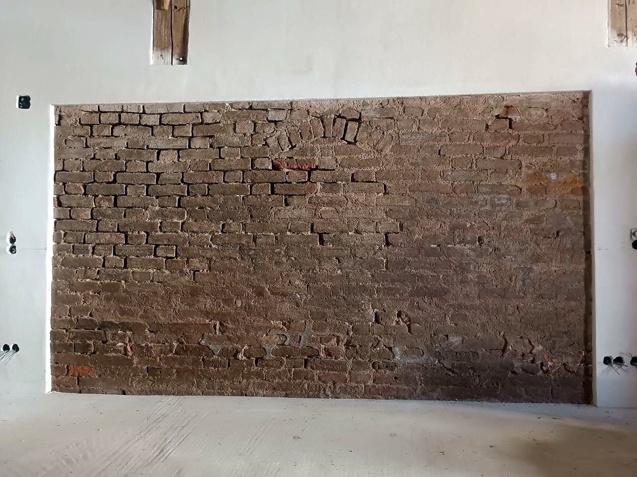 Ziegelwand mit Schmutz und Putzresten vorher