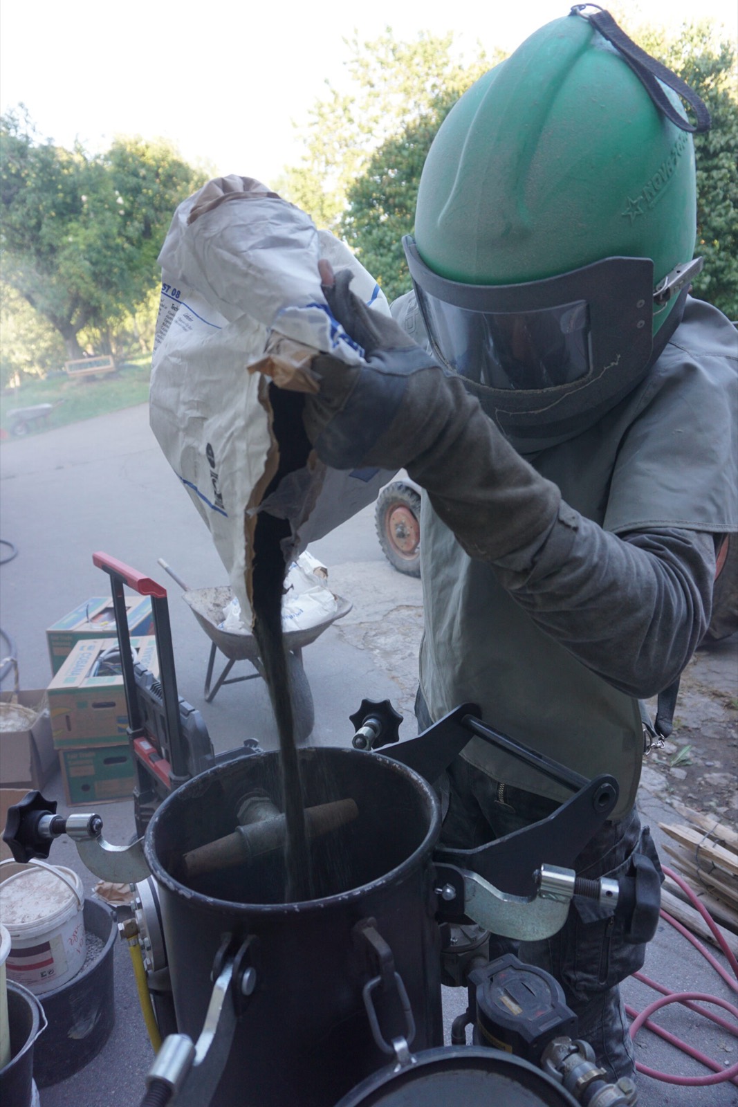 Operario de Sandblitz llena el depósito de chorreado con abrasivo